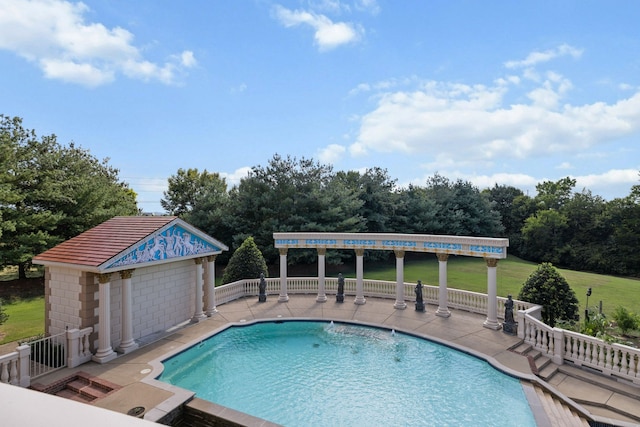 view of swimming pool with a lawn, a patio area, and an outdoor structure