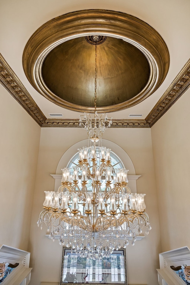 room details with crown molding, an inviting chandelier, and a tray ceiling