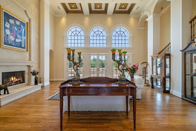 interior space with crown molding, a high ceiling, and hardwood / wood-style flooring