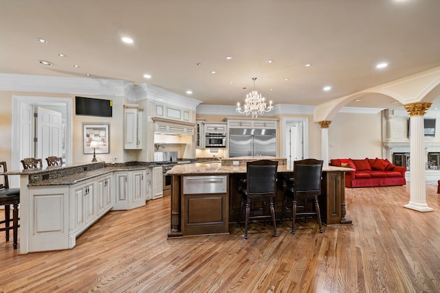 kitchen with white cabinets, an inviting chandelier, light hardwood / wood-style flooring, and stainless steel built in refrigerator