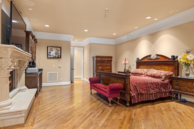 bedroom with crown molding and light hardwood / wood-style floors