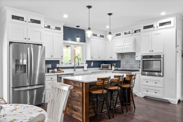 554 Hayes Ridge Rd, Indian Mound, TN 37079 - kitchen with dark hardwood / wood-style flooring, decorative light fixtures, a kitchen island, stainless steel appliances, and premium range hood