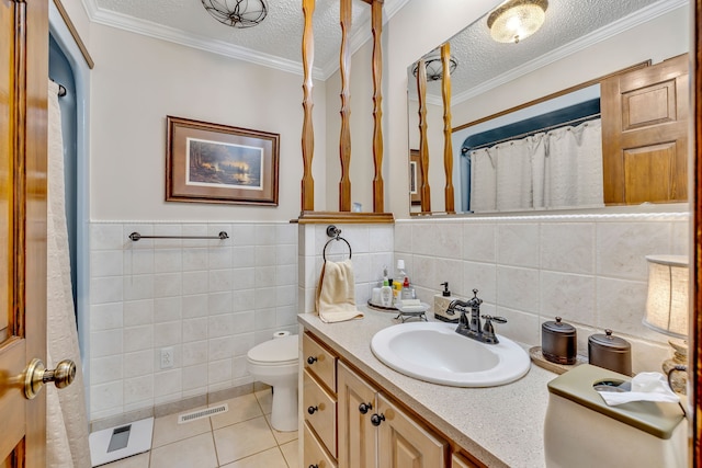 bathroom with toilet, a textured ceiling, vanity with extensive cabinet space, tile walls, and tile flooring