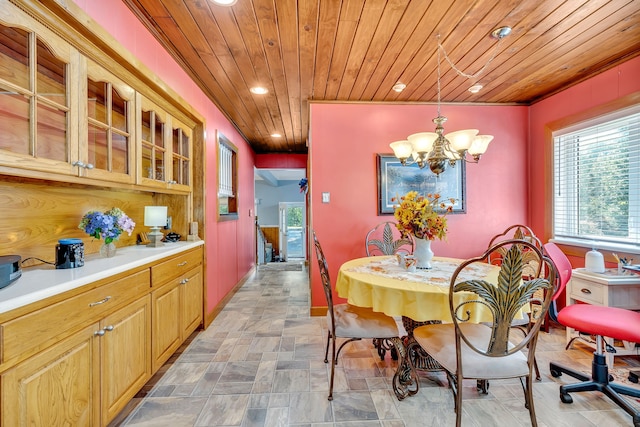 tiled dining space with an inviting chandelier, plenty of natural light, and wood ceiling