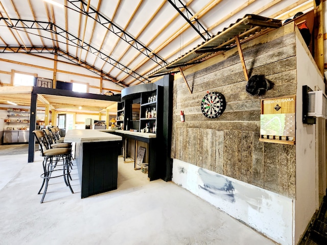 interior space with a breakfast bar and lofted ceiling