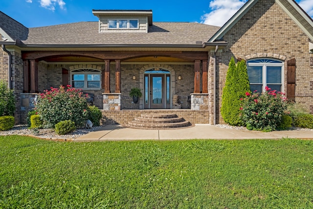 property entrance featuring a yard and covered porch