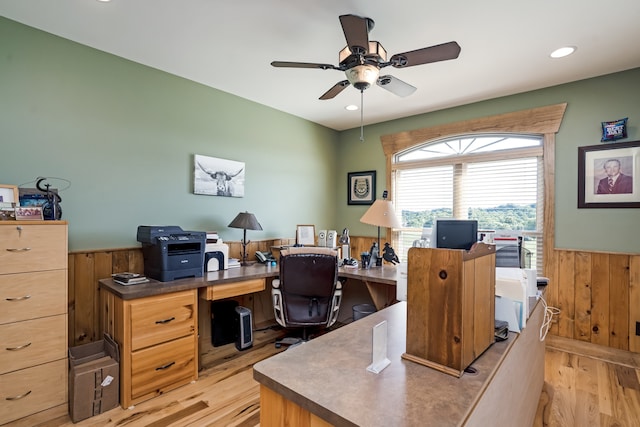 office space with ceiling fan, light hardwood / wood-style flooring, and wooden walls