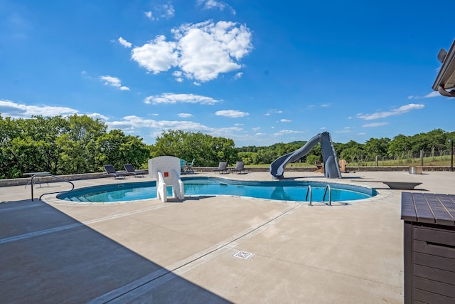 view of swimming pool with a patio and a water slide