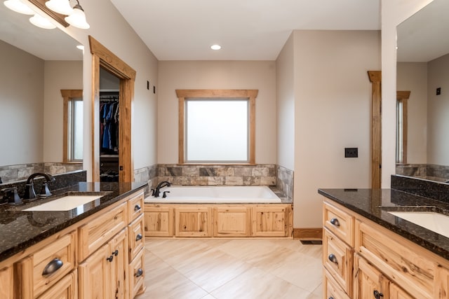 bathroom featuring a bathing tub, vanity, and tile patterned floors