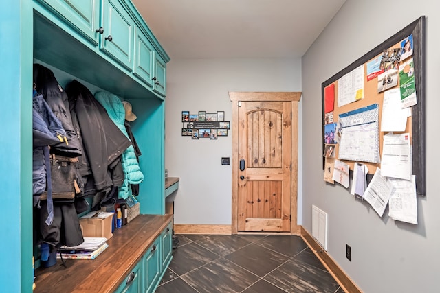 mudroom with dark tile patterned flooring