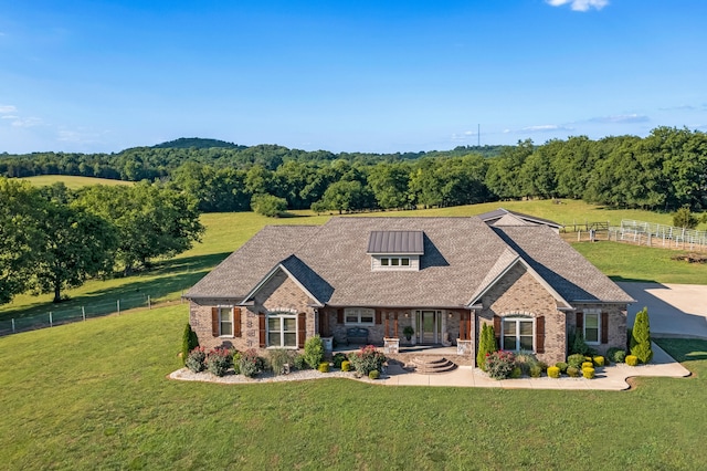 view of front of property with a rural view and a front lawn