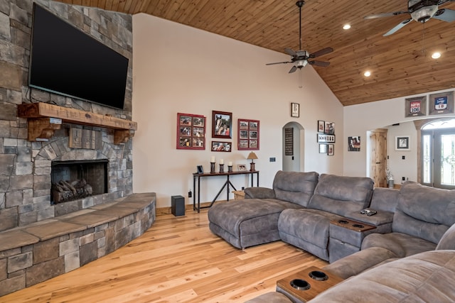 living room with light hardwood / wood-style floors, wood ceiling, a fireplace, high vaulted ceiling, and ceiling fan