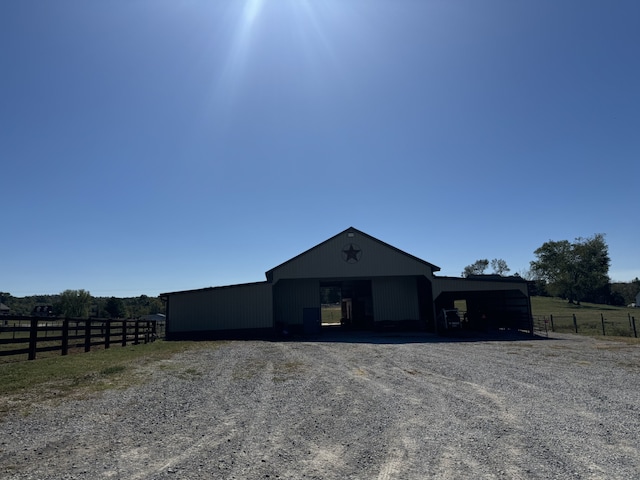 view of front facade with a carport and a rural view