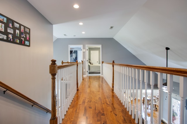 hall with light hardwood / wood-style floors and lofted ceiling