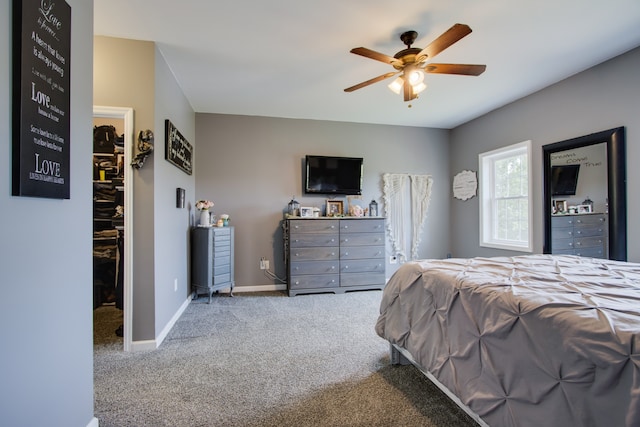 carpeted bedroom with a spacious closet, a closet, and ceiling fan