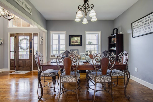 dining area with dark hardwood / wood-style floors, a healthy amount of sunlight, and a chandelier