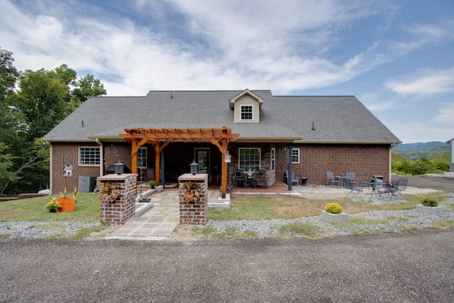 view of front of property with central AC unit, a pergola, and a patio area