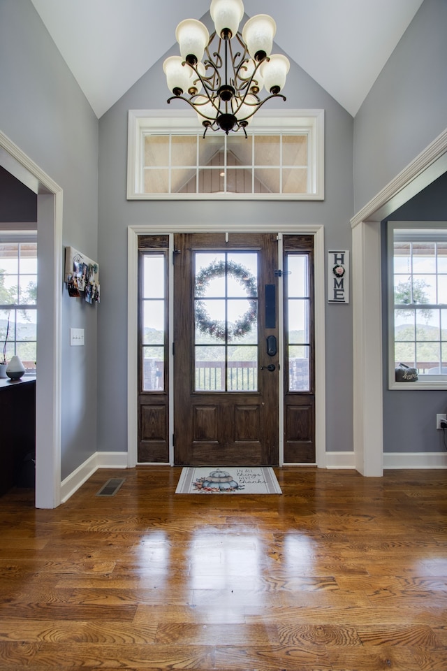 foyer featuring a chandelier, high vaulted ceiling, and dark hardwood / wood-style flooring