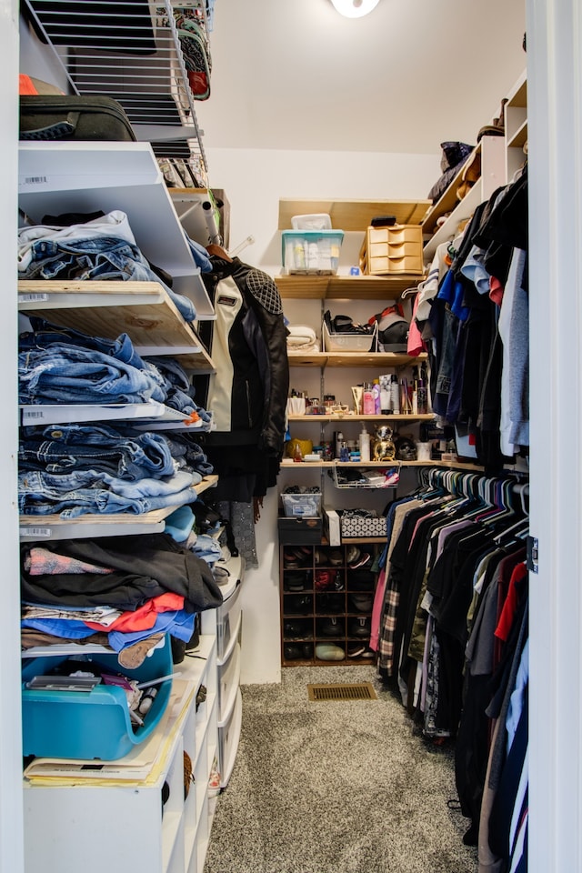 walk in closet with dark colored carpet