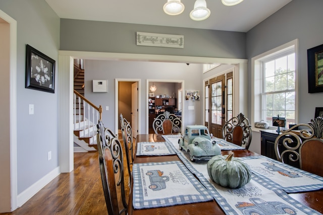 dining room with french doors, a chandelier, and dark wood-type flooring