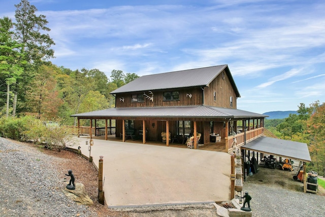 back of house featuring a porch and a carport