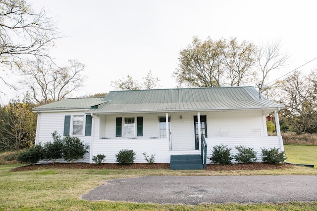 ranch-style house with a front yard and covered porch