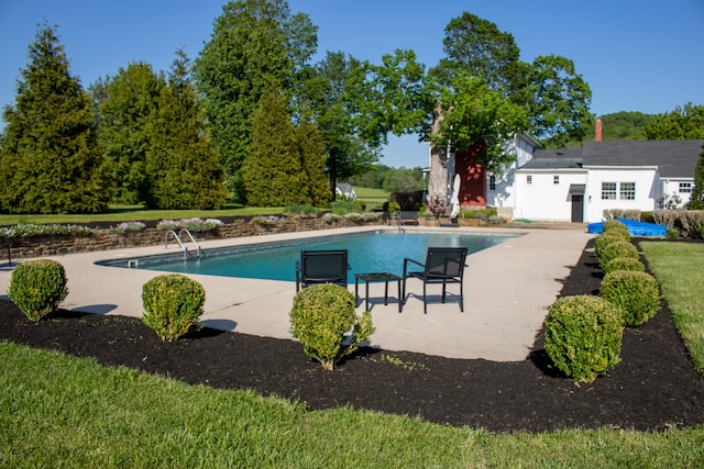 view of swimming pool featuring a patio and a lawn