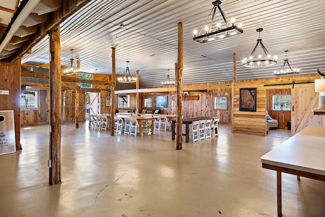 misc room with a barn door, a notable chandelier, and plenty of natural light