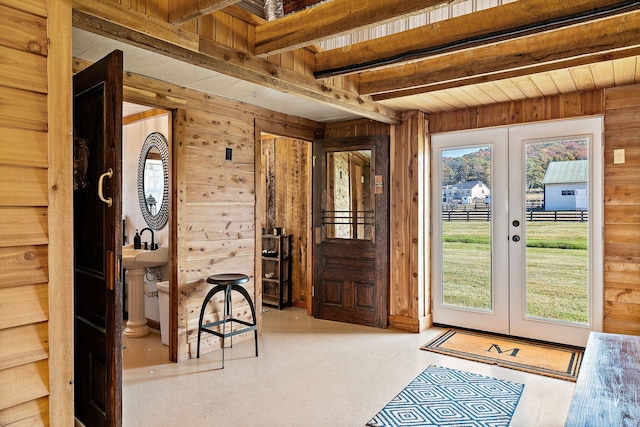 doorway to outside featuring french doors, a wealth of natural light, beamed ceiling, and wooden walls