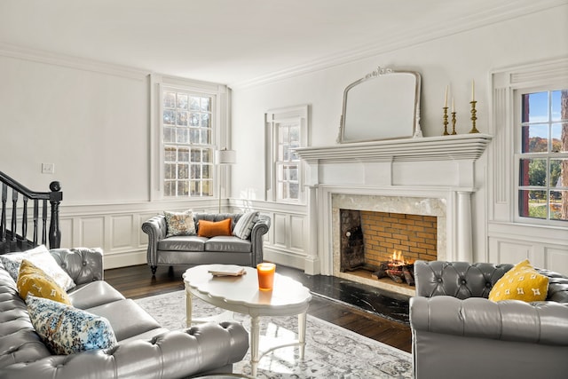 living room with a high end fireplace, dark hardwood / wood-style floors, and plenty of natural light