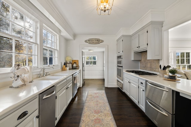 kitchen featuring backsplash, dark hardwood / wood-style floors, a notable chandelier, appliances with stainless steel finishes, and white cabinets