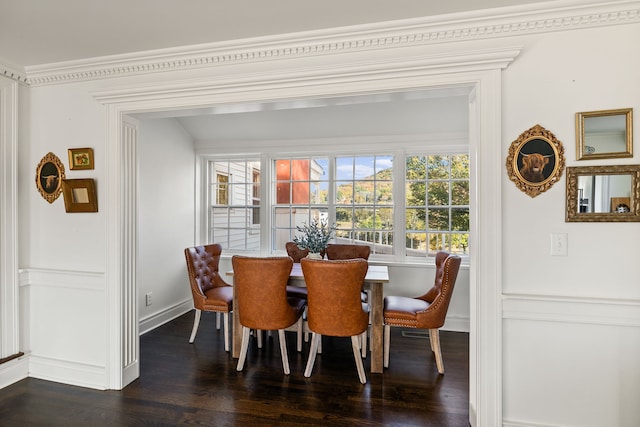 dining space with dark hardwood / wood-style flooring and ornamental molding