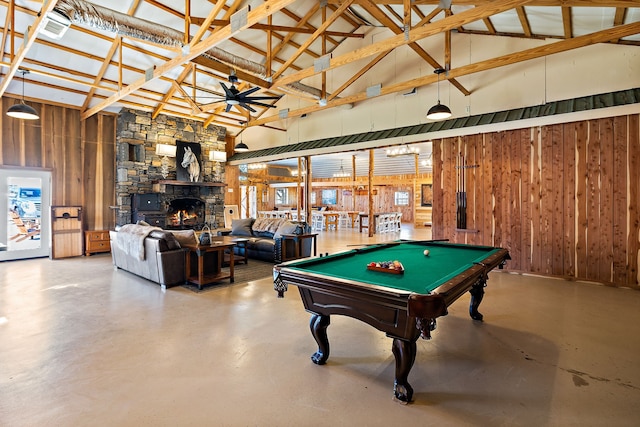 game room with ceiling fan, wooden walls, a stone fireplace, and pool table