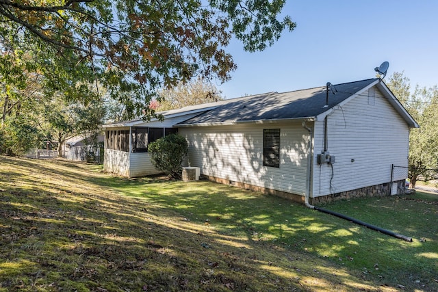 back of property with central air condition unit and a yard