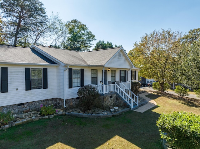 ranch-style house featuring covered porch and a front yard