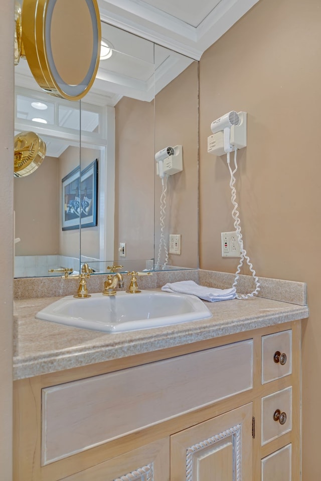 bathroom featuring crown molding and vanity with extensive cabinet space