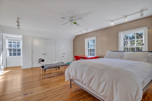 bedroom featuring rail lighting and light wood-type flooring