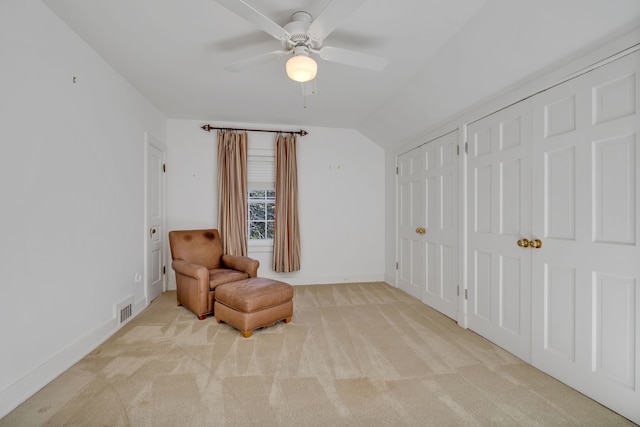 living area with ceiling fan, lofted ceiling, and light carpet