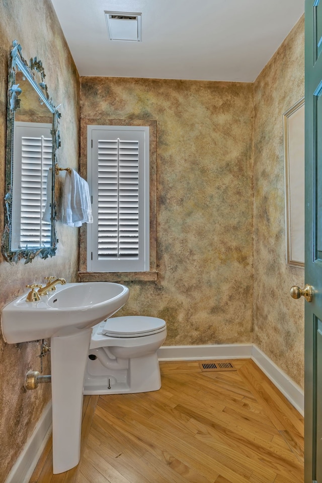 bathroom with wood-type flooring and toilet