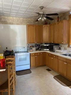 kitchen featuring white range, ceiling fan, light tile patterned flooring, and sink