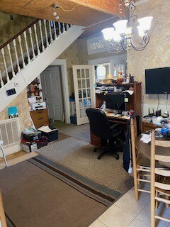 tiled home office featuring a notable chandelier