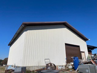 view of side of home with an outdoor structure and a garage