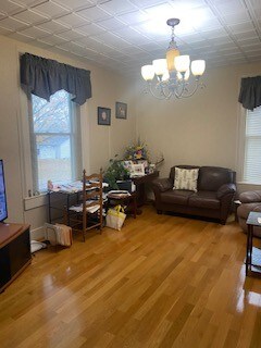 living room featuring wood-type flooring and a chandelier