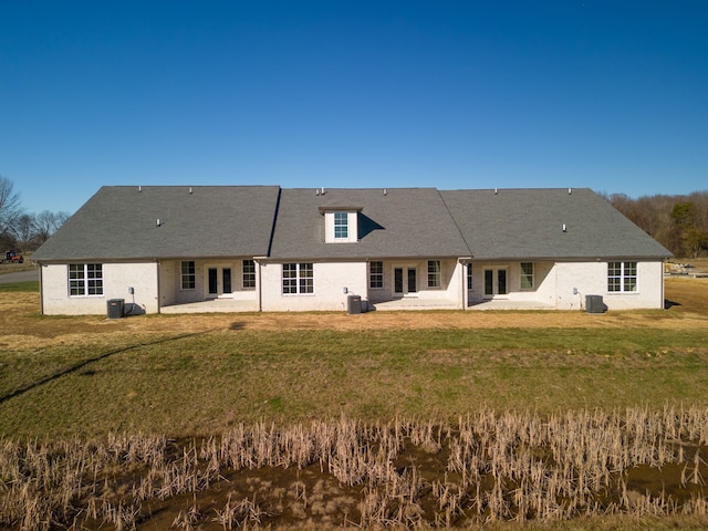 back of house featuring central AC and a lawn