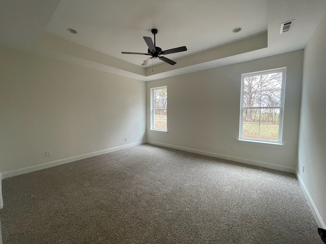 unfurnished room featuring carpet, a tray ceiling, and ceiling fan