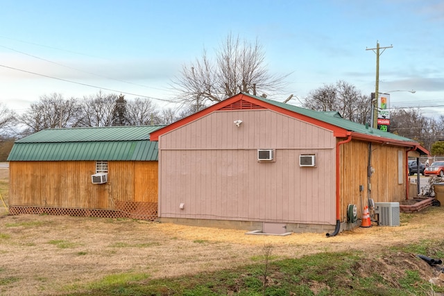 view of outdoor structure with central AC unit and a yard