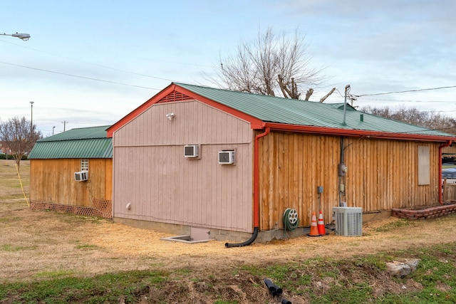 view of shed / structure with central AC unit, a wall mounted AC, and a lawn