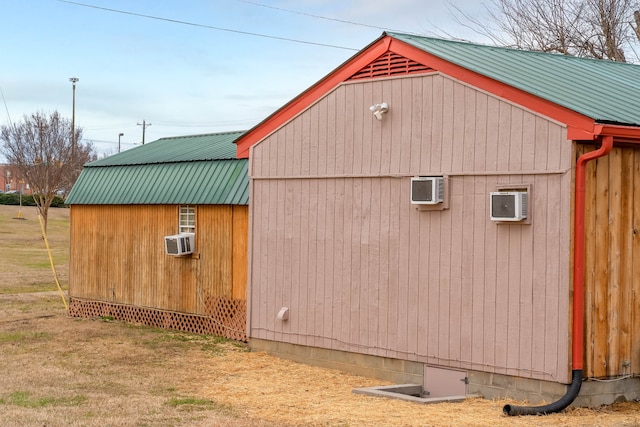 view of outdoor structure with a yard and a wall mounted air conditioner