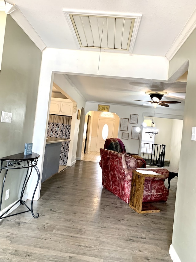 living room featuring ornamental molding, wood-type flooring, and ceiling fan