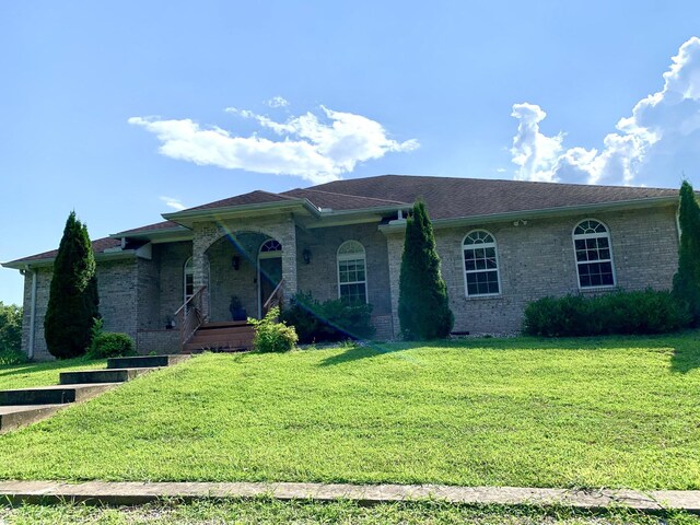 single story home featuring a front lawn